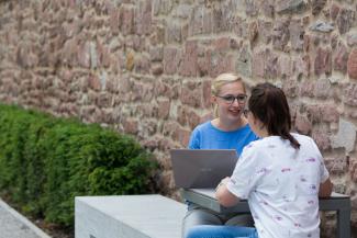 2 Studentinnen mit Laptop im Gespräch