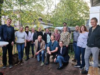 Gruppenfoto der Teilnehmenden des Auftakttreffens auf der von Bäumen gerahmten Terrasse der HSE.