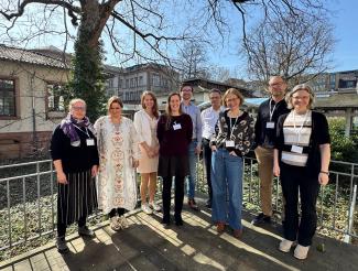 Die sieben HSE-Fellows PD Dr. Joséphine Jacquier, Prorektorin Prof. Dr. Silke Hertel, Prof. Dr. Susanne Mantel, AOR Dr. Hendrik Kasten, Prof. Dr. Matthias Bartelmann, Dr. Sylvia Brockstieger, Prof. Dr. Matthias Weidemüllerauf der sonnigen HSE-Terrasse, eingerahmt von Johanna Ruge und Dr. Christiane Wienand.