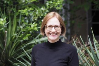 Porträt von Dr. Sylvia Brockstieger vor Pflanzenkulisse