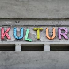 Auf grauem Mauerwerk bilden bunte, etwas verwitterte Lettern das Wort KULTUR