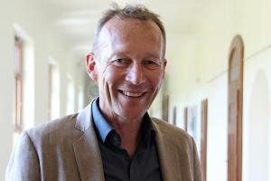 Prof. Dr. Manfred Seidenfuß im Flur des Altbaus der Pädagogischen Hochschule. Er lächelt in die Kamera.