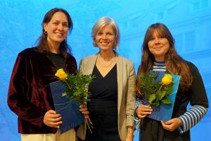 Das Bild zeigt die Preisträgerinnen Alessia-Valeska Schieron und Dr. Anna-Maria Jünger, in den Händen eine gelbe Rose. Zwischen ihnen steht Dr. Frauke Janz vom Gleichstellungsbüro. | Bild: PHHD