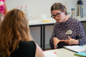 Das Bild zeigt die Bildungsfachkraft Anna Neff in einem Workshop mit einer Teilnehmerin.
