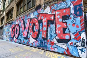 Das Bild zeigt ein Graffitti auf einer Mauer mit dem Schriftzug GO VOTE.