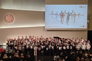 Gruppenfoto der Absolvent:innen des Jahrgangs 2025 auf der Bühne der Neuen Aula