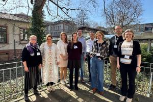 Die sieben HSE-Fellows PD Dr. Joséphine Jacquier, Prorektorin Prof. Dr. Silke Hertel, Prof. Dr. Susanne Mantel, AOR Dr. Hendrik Kasten, Prof. Dr. Matthias Bartelmann, Dr. Sylvia Brockstieger, Prof. Dr. Matthias Weidemüllerauf der sonnigen HSE-Terrasse, eingerahmt von Johanna Ruge und Dr. Christiane Wienand.