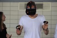 Student mit VR-Brille und Controllern probiert digitale Sporteinheit aus