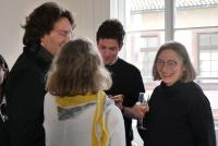 Eine lachende Petra Deger im Gespräch mit Michael Haus, Christiane Wienand, Sebastian Mahner; in ihrer Hand ein Sektglas.