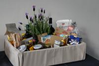 Ein Präsentkorb mit italienischen Köstlichkeiten und einer blühenden Lavendelpflanze