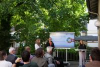 Sitzende Teilnehmende des HSE-Terrassengesprächs sind von der Seite zu sehen wie sie nach vorne auf ein Smartboard schauen. Neben dem Smartboard stehen Theresa Ruckelshauß, Prof. Dr. Alexander Siegmund und Dr. Johanna Weselek. Auf dem Smartboard stehen Diskussionsanregungen.