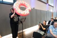 Dr. Nicole Aeschbach bei ihrem Beitrag zum Science Contest. Sie hält einen aufgeblasenen pinkfarbenen Donut in die Höhe.