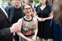 Wiebke Goltz im geblümten Kleid lächelt in die Kamera. Hinter ihr weitere Gäste der Feier.