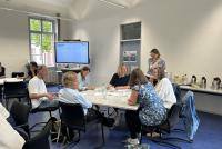 Teilnehmende des Zukunftsforums sitzen in der Workshop-Phase an Tischen gruppiert im Konferenzraum der HSE.