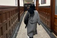 Eine junge Frau von hinten im holzvertäfelten Gang des Teachers College auf dem Weg zur Grace Dodge Hall.