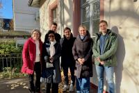 Gruppenfoto von Dr. Christiane Wienand, Dr. Portia Williams, Dr. Sebastian Mahner, Dr. Lina Pranaityte und Dr. Dietz auf der Terrasse der HSE in der Wintersonne.
