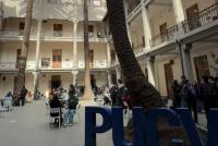 Palmenbegrünter Innenhof der Casa Central mit den großen Buchstabenaufstellern PUCV