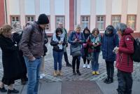 Teilnehmende der Staff Week stehen auf dem Uniplatz und lesen die Inschrift der in den Boden eingelassenen Gedenktafel zur Bücherverbrennung vom 17. Mai 1933.