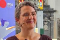 Wiebke Steinleitner bei ihrem Vortrag zur in der Peterskirche. Im Hintergrund das Roll-up zur Akademischen Mittagspause.