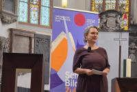 Wiebke Steinleitner bei ihrem Vortrag zur in der Peterskirche. Im Hintergrund das Roll-up zur Akademischen Mittagspause.